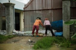 Two women put stack sandbags to keep rising waters from flooding their house in Spean Tmor commune, Dangkoa district, Phnom Penh, Cambodia, on Oct. 14, 2020. (Malis Tum/VOA Khmer)