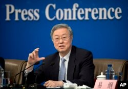 Zhou Xiaochuan, governor of the People's Bank of China, gestures while speaking during a press conference held on the sidelines of the annual meeting of China's National People's Congress in Beijing, March 10, 2017.