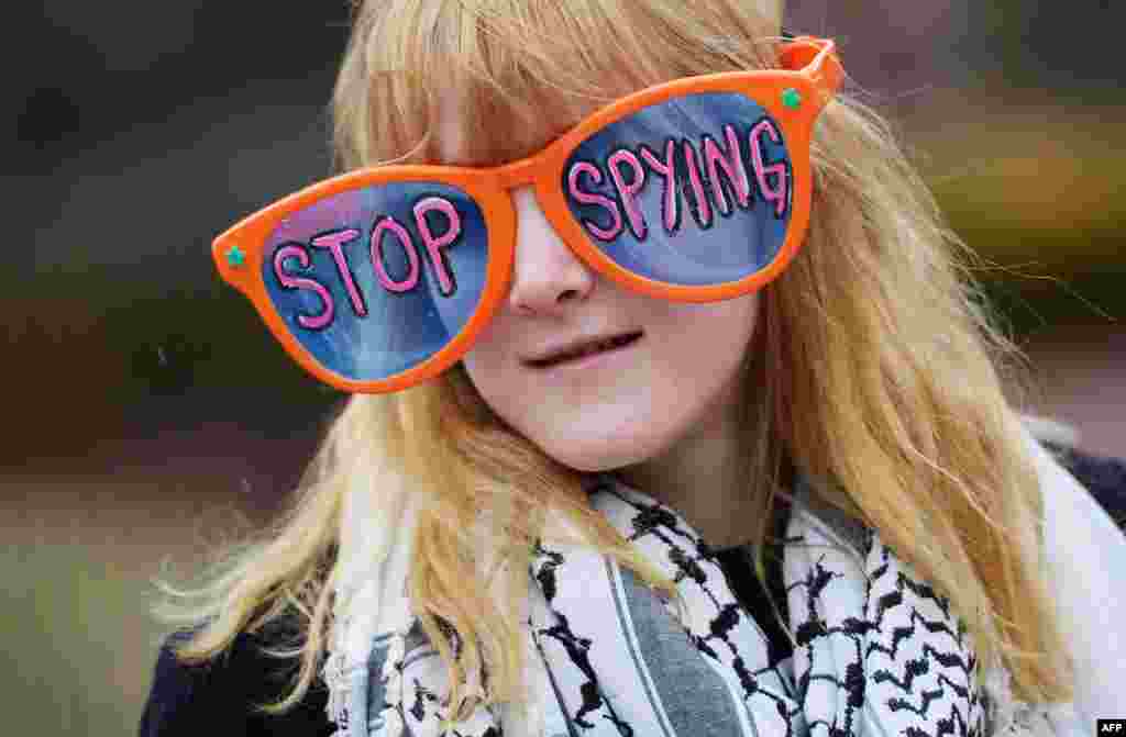 A woman wears large sunglasses with a message during a rally in Lafayette Square in Washington, D.C., to call for an end to government surveillance.