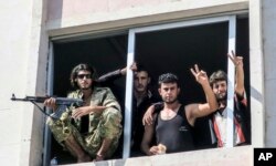 FILE - Free Syrian Army fighters gesture in Jarablus, Syria, Aug. 31, 2016.