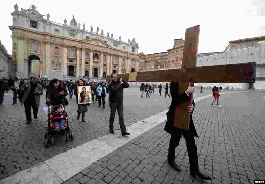 Pilgrims carry a cross on Saint Peter's Square at the Vatican, March 11, 2013.