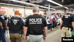 Petugas Penegakan Immigrasi dan Bea Cukai AS (ICE) saat melakukan penangkapan migran gelap di fasilitas pemrosesan pertanian di Canton, Mississippi, AS, 7 Agustus 2019. 