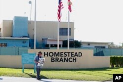 A protester demonstrates in front of the Homestead Temporary Shelter for Unaccompanied Children in Homestead, Fla., Feb. 19, 2019.