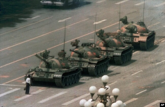 FILE - A Chinese man stands alone to block a line of tanks heading east on Beijing's Cangan Boulevard in Tiananmen Square, June 5, 1989. (AP Photo/Jeff Widener)