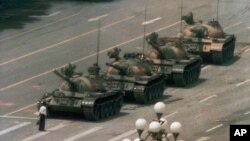 FILE - A Chinese man stands alone to block a line of tanks heading east on Beijing's Cangan Boulevard in Tiananmen Square, June 5, 1989.