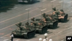 FILE - A Chinese man stands alone to block a line of tanks heading east on Beijing's Cangan Boulevard in Tiananmen Square, June 5, 1989. 