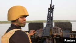 Un officier de la marine devant une mitrailleuse, sur un bateau, au large de la côte atlantique dans l'Etat de Bayelsa, Nigeria, 19 décembre 2013.