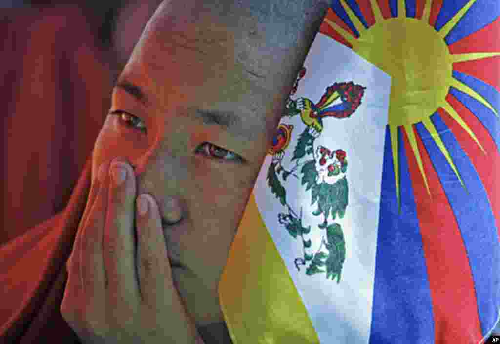 A Tibetan monk holds a flag as he takes part in a day-long hunger strike in New Delhi, October 19, 2011.
