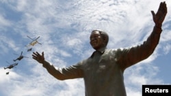 A bronze statue of the late former South African President Nelson Mandela is unveiled at the Union Buildings in Pretoria, Dec. 16, 2013.