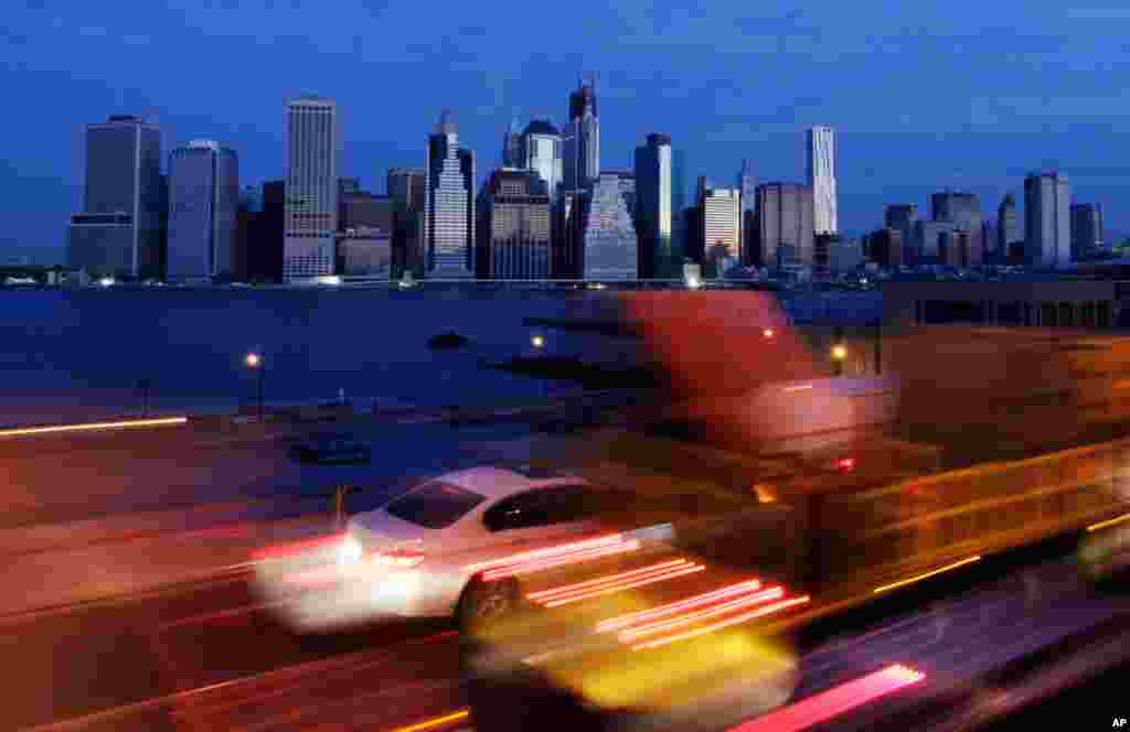 Early morning traffic in Brooklyn, New York moves slowly beneath the still-dark Manhattan skyline, November 1, 2012. New York is trying to resume its normal frenetic pace, but still finding it slow going on gridlocked highways.