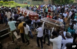 Sri Lankans carry the coffins with the remains of two men who were killed in the Easter Sunday bombings in Colombo, Sri Lanka, April 23, 2019.