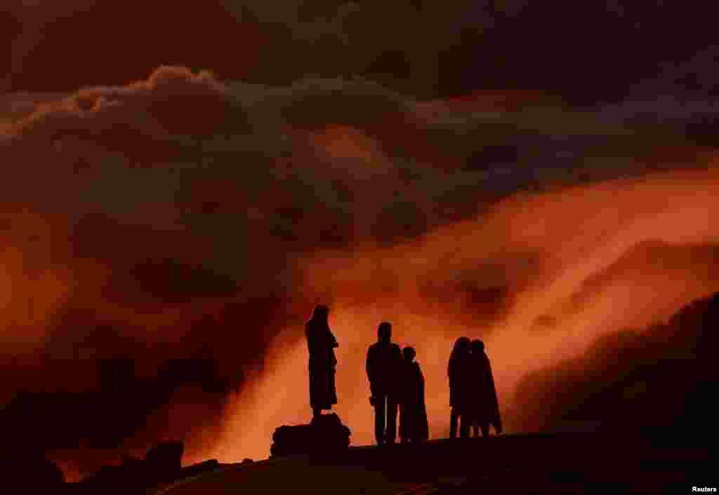 Light illuminates clouds as people watch the sunrise at Haleakala National Park in Hawaii, Oct. 9, 2018.