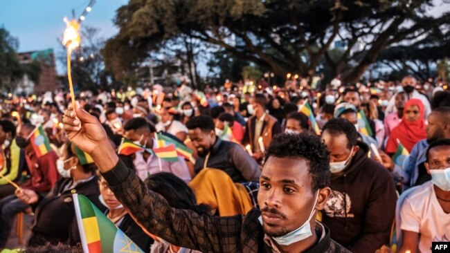 A man holds a candle during a memorial service for the victims of the Tigray conflict, organized by the city administration, in Addis Ababa, Ethiopia, on Nov. 3, 2021.