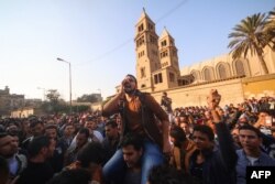FILE - Egyptians gather outside the Saint Peter and Saint Paul Coptic Orthodox Church in Cairo's Abbasiya neighborhood after it was targeted by a bomb, Dec. 11, 2016.