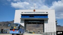 This photo taken on April 8, 2019 shows a tour bus driving past the border between China and North Korea as it makes its way to North Korea, in Ji'an in China's northeastern Jilin province. - The new highway border crossing opened in the northeastern city