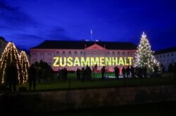 Instalasi lampu "Ray of Hope" menerangi Bellevue Palace, tempat kediaman Presiden Jerman Frank-Walter Steinmeier, di Berlin, Jerman, 15 Desember 2020.