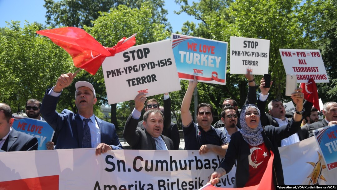 Pendukung Presiden Turki Recep Tayyip Erdogan bereaksi terhadap demonstran anti-Erdogan di luar Gedung Putih di Washington DC, Selasa (16/5).