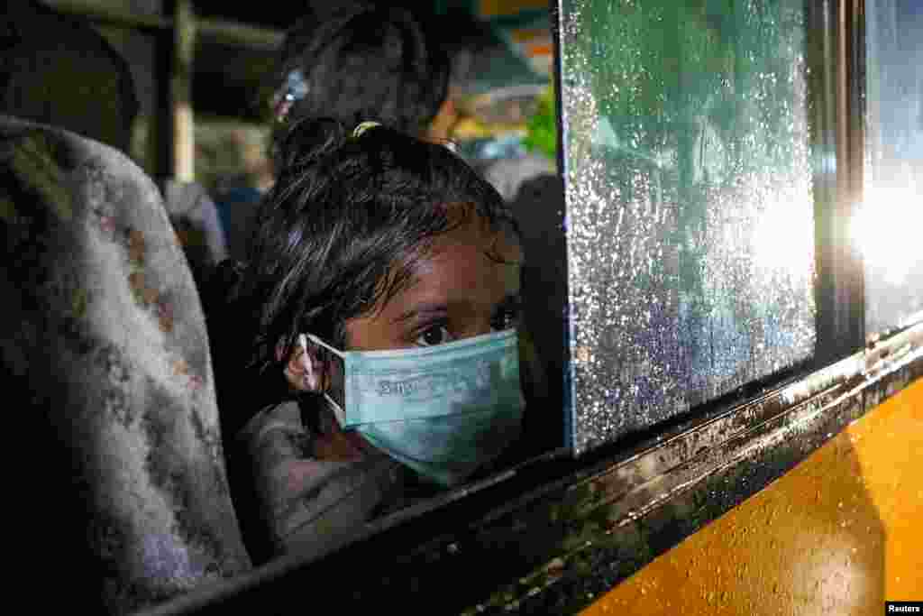 A Rohingya child looks on near a window of a bus during an evacuation after arriving by boat at a port in Krueng Geukuh near Lhokseumawe, North Aceh, Indonesia.