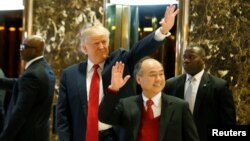 Presiden AS terpilih Donald Trump dan CEO Softbank Masayoshi Son melambaikan tangan pada para tamu setelah melakukan pembicaraan di Trump Tower di Manhattan, kota New York (6/12). (Reuters/Brendan McDermid)