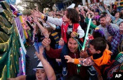 Revelers scream for beads during the Krewe of Endymion Mardi Gras parade in New Orleans, Saturday, Feb. 25, 2017.