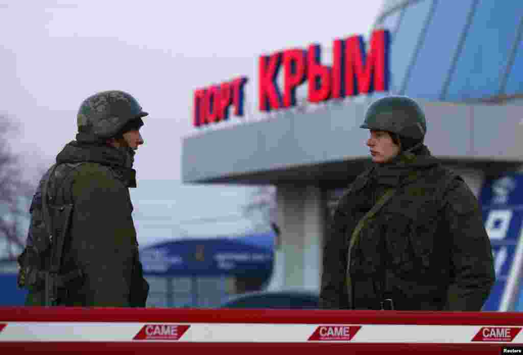 Armed men, believed to be Russian soldiers, stand outside the civilian port in the Crimean town of Kerch, March 3, 2014. 