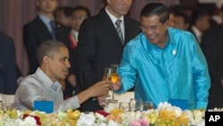 U.S. President Barack Obama, left, toasts with Cambodia's Prime Minister Hun Sen at the East Asia Summit Dinner during the East Asia Summit at the Diamond Island Convention Center in Phnom Penh, Cambodia, Monday, Nov. 19, 2012. (AP Photo/Carolyn Kaster)