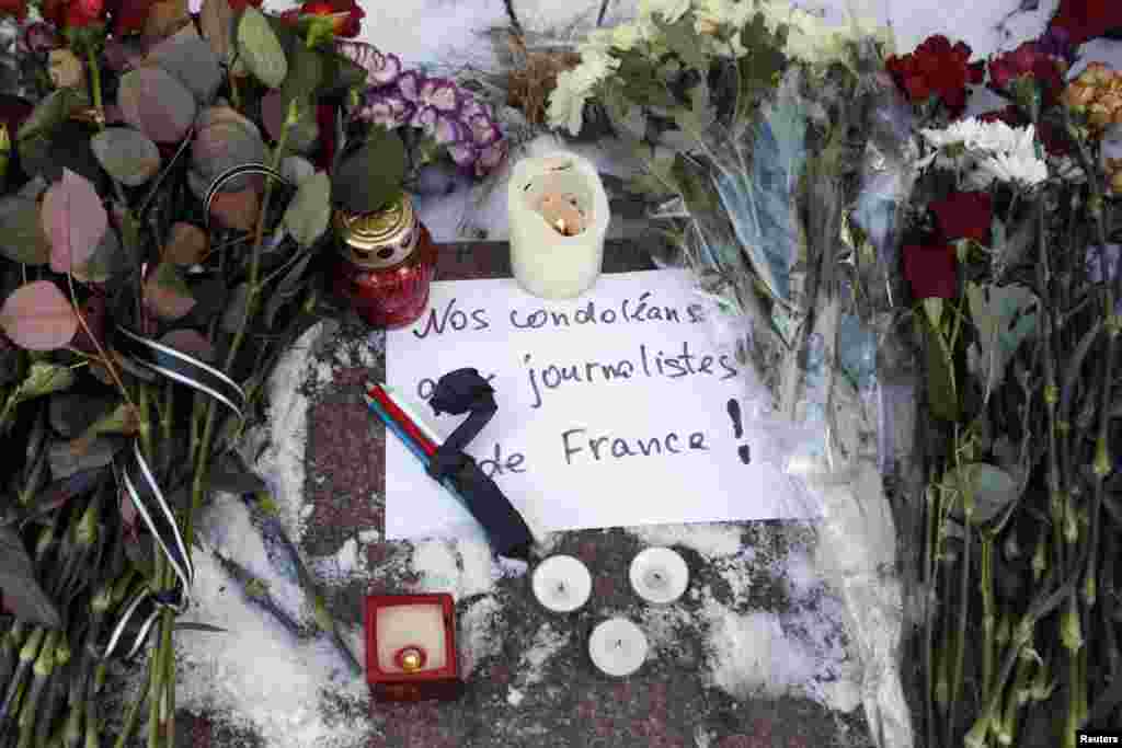 Candles, condolence flowers and pencils for the victims of the shooting at Charlie Hebdo are placed outside the French embassy in Kyiv, Jan. 8, 2015.