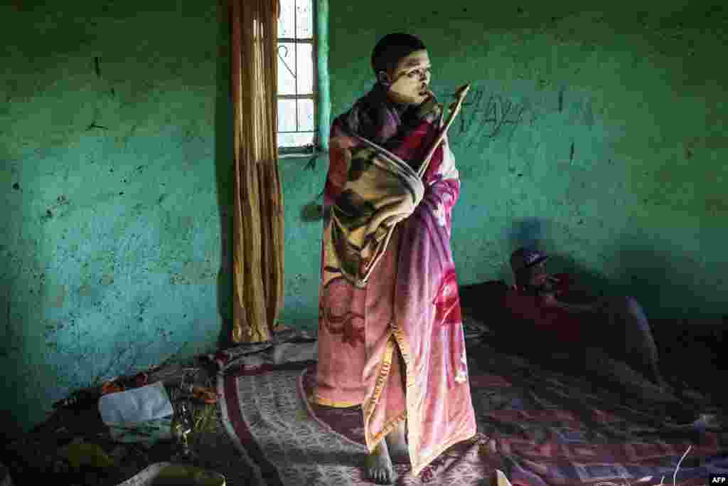 Traditional Xhosa initiate Fezikhaya Tselane, 20 years old, stands during a traditional initiation process in a rural hut in the Coffee Bay area in Umtata, South Africa.