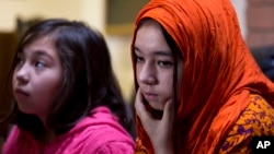 In this Nov. 29, 2018 photo, Shahnaz, 16, right, and Shakeela, 12, daughters of Mir Aman, speak to The Associated Press, in Islamabad, Pakistan.