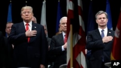FILE - President Donald Trump, Attorney General Jeff Sessions, center and FBI Director Christopher Wray stand during the National Anthem at the FBI National Academy graduation ceremony in Quantico, Va. 