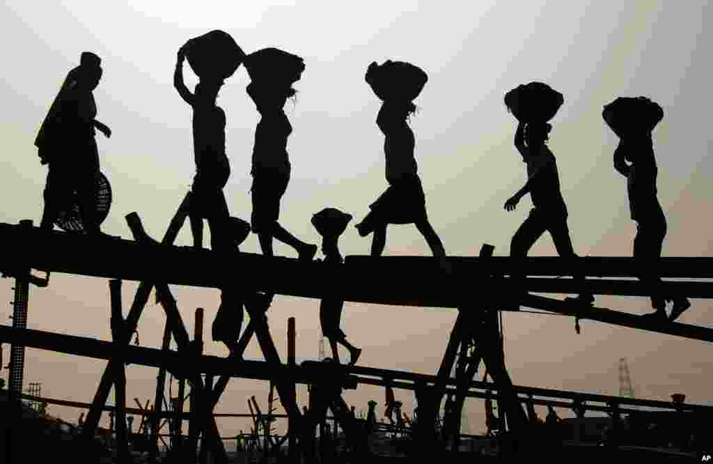 Bangladeshi laborers unload coal from a boat, on the last day of a four-day blockade called by the opposition in Dhaka.