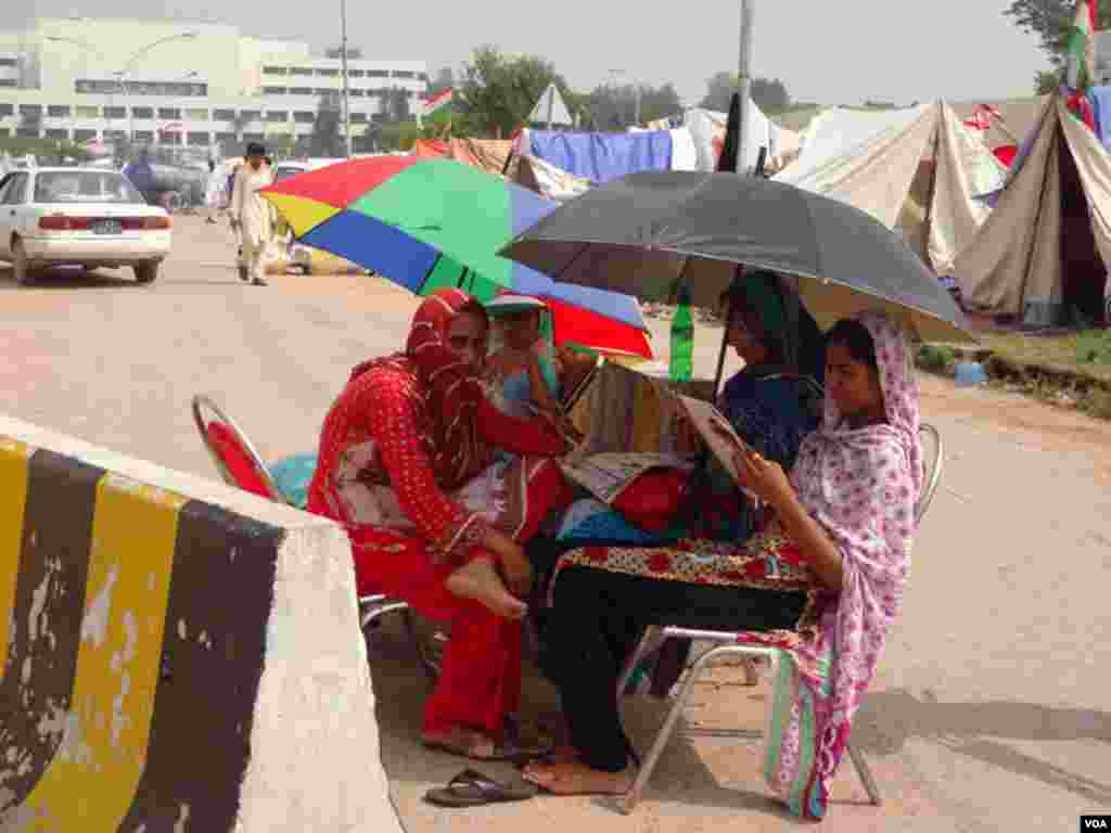 پارلیمنٹ کے باہر موجود دھرنے میں موجود نوجوان لڑکیاں اخبار کا مطالعہ اور گفتگو میں وقت گزارتی ہیں