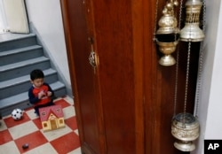 FILE - David Carvajal, 2, plays in the hallway of the Holyrood Episcopal Church in northern Manhattan, Oct. 26, 2017.