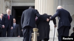 U.S. Senate Minority Leader Mitch McConnell (L) watches as Senator Mark Kirk (2nd R) works his way up the Senate steps with the assistance of Senator Joe Manchin (2nd L) and U.S. Vice President Joseph Biden on his return to the U.S. Senate on Capitol Hill, Washington, January 3, 2013.