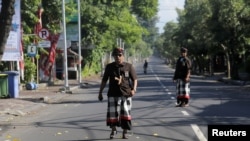 Para penjaga Hindu Bali, yang dikenal sebagai Pecalang, berpatroli di jalanan dekat Bandara Internasional Ngurah Rai pada hari hening, menjelang pelaksanaan Nyepi di Bali (foto: ilustrasi). 