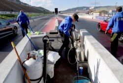 Seorang awak kru menyiapkan trek di Bandimere Speedway, di barat Denver, 5 Mei 2021. Dinas Patroli Negara Bagian meluncurkan program "Take it to the Track" untuk mengatasi balap liar yang berbahaya. (Foto:Thomas Peipert/AP)