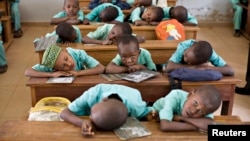 FILE - Muslim boys rest their heads on their desks during a language class at Al-Haramain madrassa at the Islamic Complex in Cameroon's capital Yaounde. Teachers, especially in the north, are afraid to return to their classrooms because of Boko Haram. 