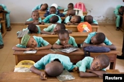 FILE - Muslim boys rest their heads on their desks during a language class at Al-Haramain madrassa at the Islamic Complex in Cameroon's capital Yaounde.