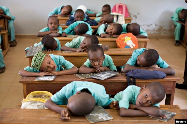 FILE - Muslim boys rest their heads on their desks during a language class at Al-Haramain madrassa at the Islamic Complex in Cameroon's capital Yaounde.