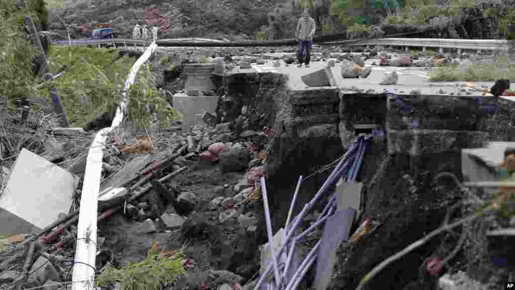 A man walks at a damaged area by earthquakes in Minamiaso, Kumamoto prefecture, April 17, 2016.