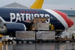 Palettes of N95 respirator masks are off-loaded from the New England Patriots football team's customized Boeing 767 jet on the tarmac, Thursday, April 2, 2020, at Logan Airport in Boston, after returning from China.