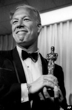 FILE - George Kennedy poses with his Oscar in Santa Monica, California, after winning best supporting actor for "Cool Hand Luke," April 10, 1968.