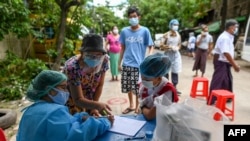 ရန်ကုန်မြို့မှာ COVID-19 ကူးစက်ပျံ့နှံ့မှု ထိန်းချုပ်နိုင်ရေး ဒေသံခတွေကို ကျန်းမာရေးစစ်ဆေးဖို့ ပြင်ဆင်နေတဲ့ ကျန်းမာရေးဝန်ထမ်းများ။ (စက်တင်ဘာ ၉၊ ၂၀၂၀)