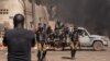 A protestor faces security forces during a demonstration in Ouagadougo, Burkina Faso, Nov. 27, 2021.