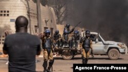 A protestor faces security forces during a demonstration in Ouagadougo, Burkina Faso, Nov. 27, 2021.