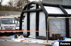 Police tape and bagged items are seen near an inflatable structure in the courtyard of Ashley Wood Recovery; where emergency services worked following the poisoning of former Russian intelligence officer Sergei Skripal and his daughter Yulia; in Salisbury, Britain, March 14, 2018.