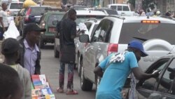 Des vendeurs à la sauvette dans les feux tricolores : un autre débouché pour les diplômés sans emplois béninois à Cotonou, au Bénin, le 26 avril 2021. (VOA/Ginette Fleure Adandé)