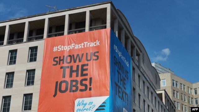 Cartel en protesta del tratado en el edificio de la Federación Americana de Trabajadores (AFL-CIO) en Washington,  que dice "Muéstrennos los empleos".