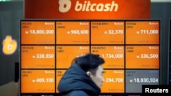 A man walks past an electric board showing exchange rates of various cryptocurrencies including Bitcoin (top-L) at a cryptocurrencies exchange in Seoul, South Korea, Dec. 13, 2017. 