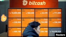 A man walks past an electric board showing exchange rates of various cryptocurrencies at a cryptocurrencies exchange in Seoul, South Korea, Dec. 13, 2017. 